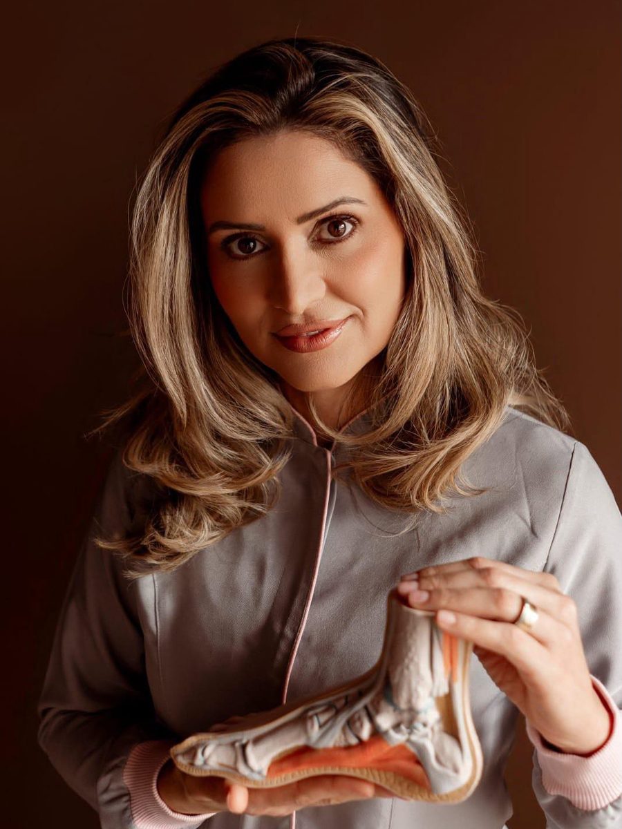 Podóloga Gizlaine Vaz, especialista em podologia em Sorocaba, segurando modelo anatômico do pé
